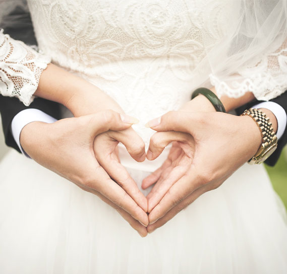 Hochzeitspaar formt ein Herz mit den Händen